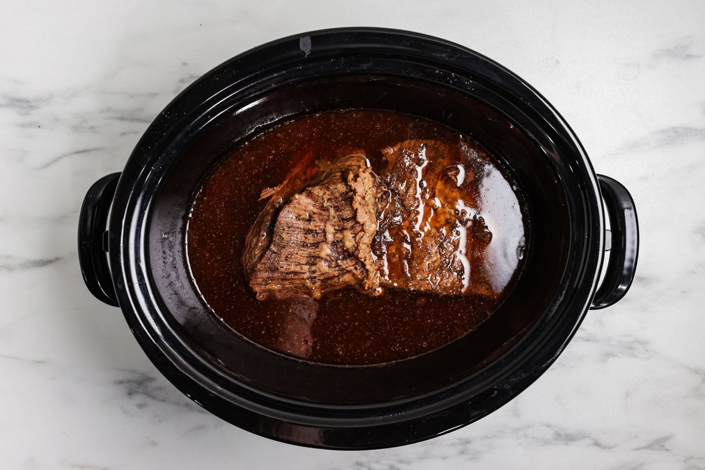 brisket in crock of slow cooker after being cooked