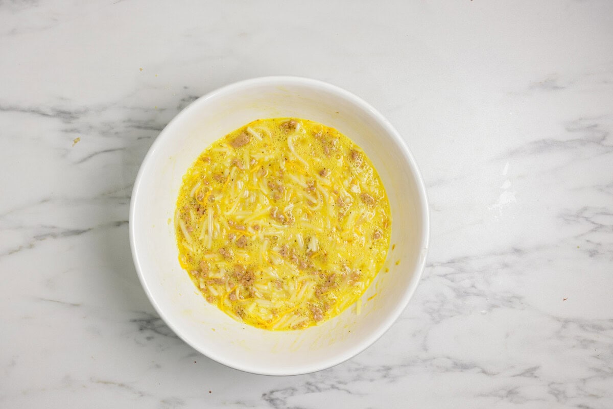 Turkey hash brown casserole ingredients mixed together in a bowl