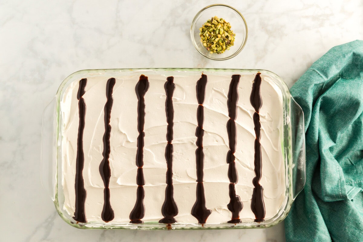 chocolate sauce drizzled in lines on top of the cool whip layer
