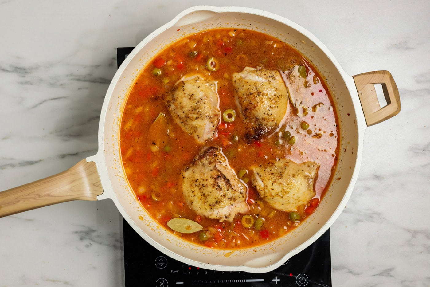 cooked chicken thighs added back to broth in skillet