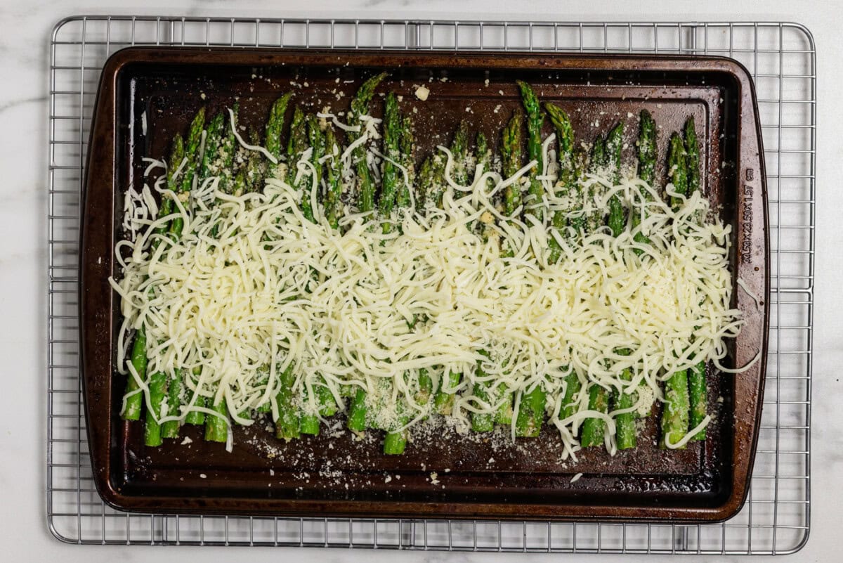 pan of asparagus with mozzarella cheese sprinkled on top