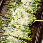spatula lifting Cheesy Asparagus off pan