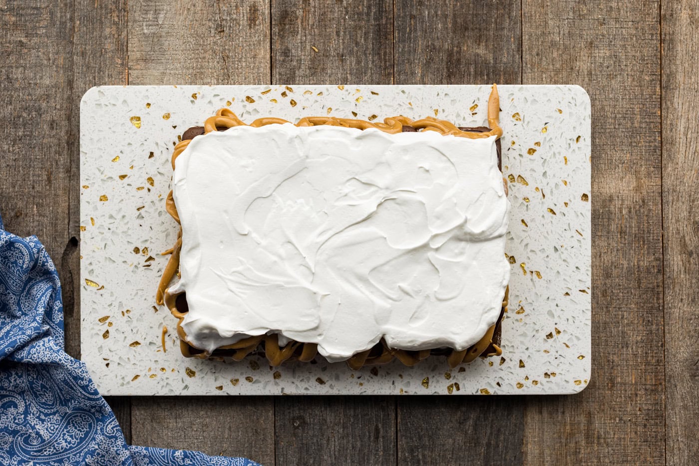 whipped cream spread over peanut butter and hot fudge layer of ice cream sandwich cake