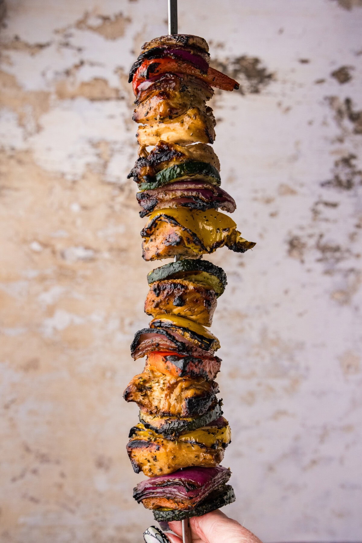 hand holding a ingle Marinated Grilled Chicken Kabob