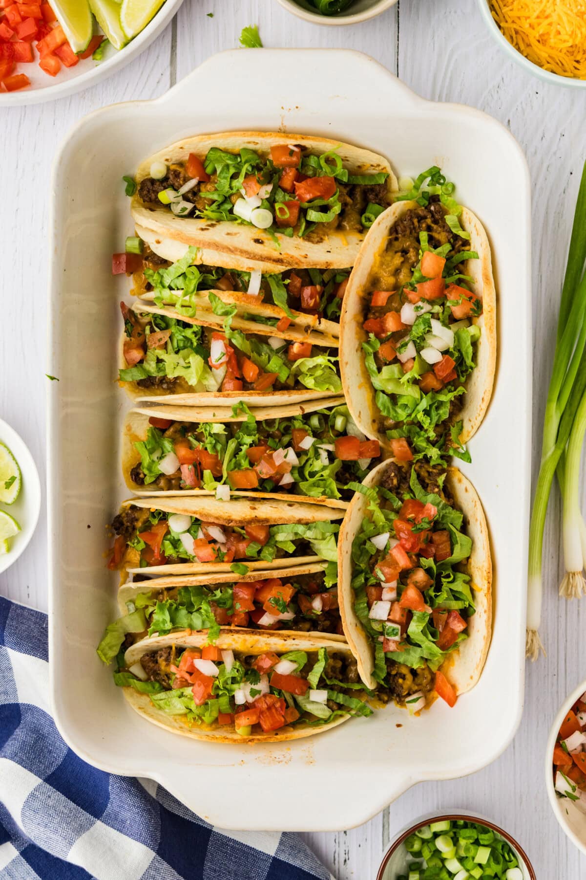 overhead photo of oven tacos with toppings in pan