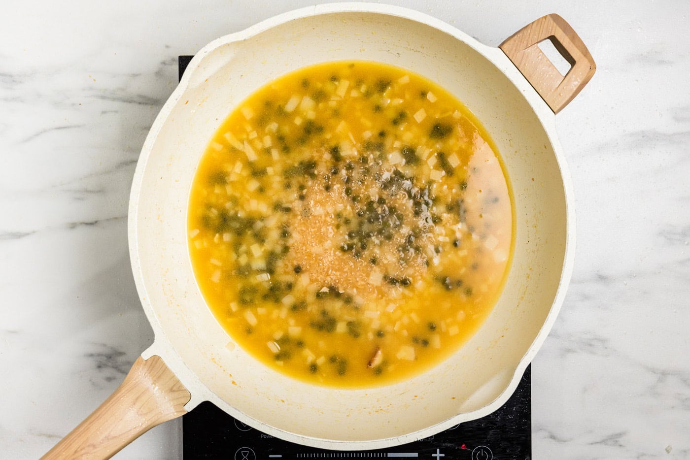 capers and broth in skillet