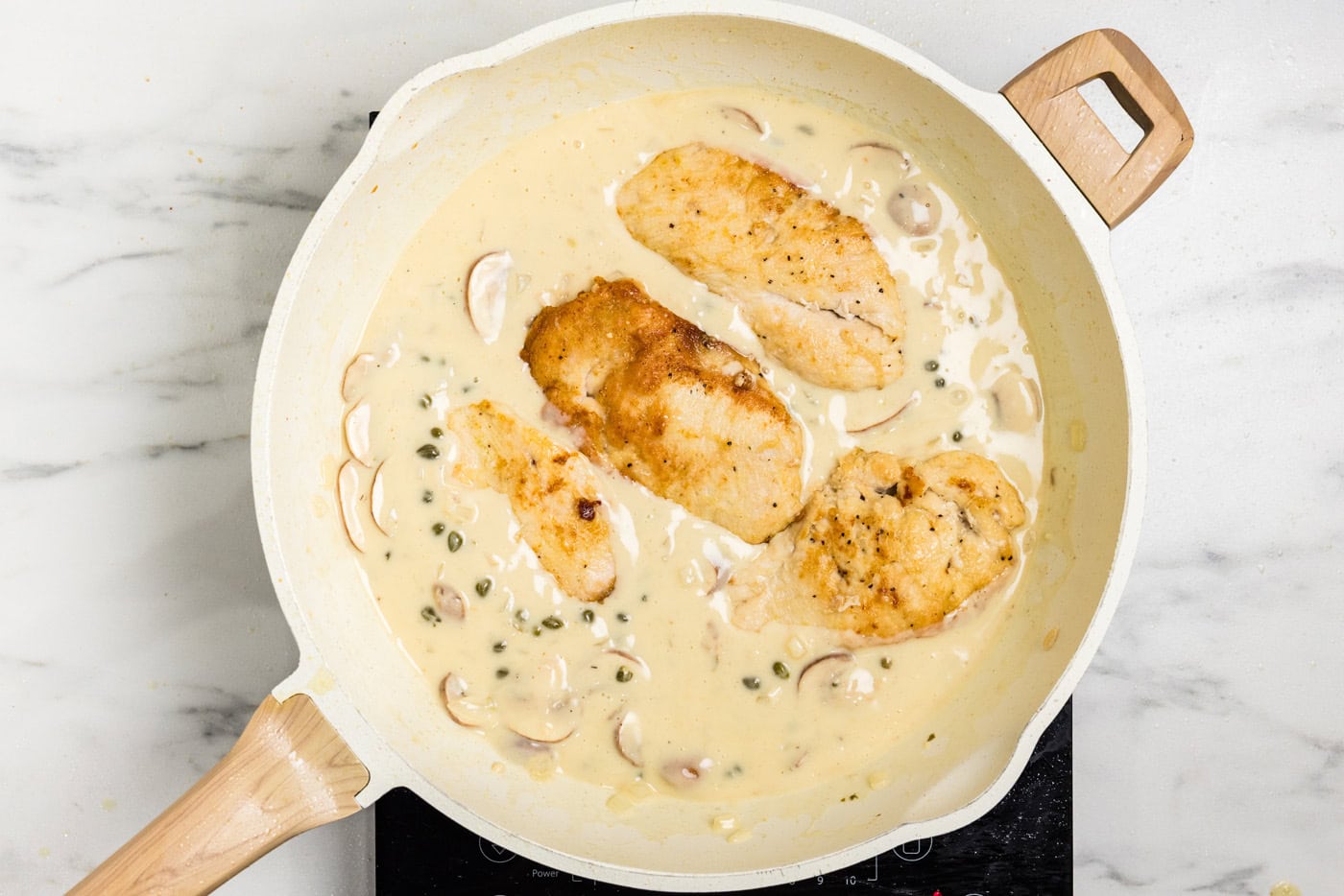 chickn cutlets in Chicken Scallopini sauce in skillet