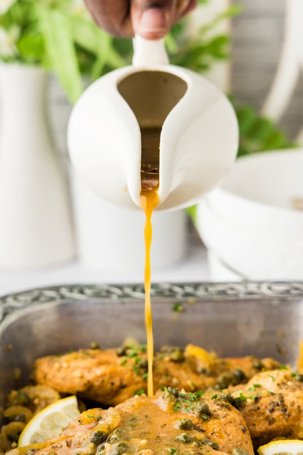 au just pouring onto Crockpot Lemon Chicken from gravy boat