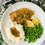 Crockpot Lemon Chicken on plate with potatoes and peas