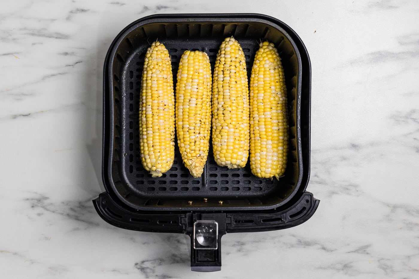 raw seasoned corn in air fryer basket