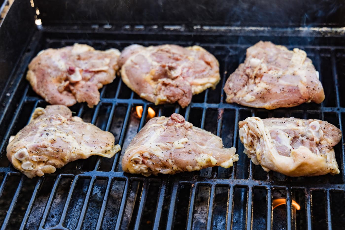 chicken thigh cooking on the grill