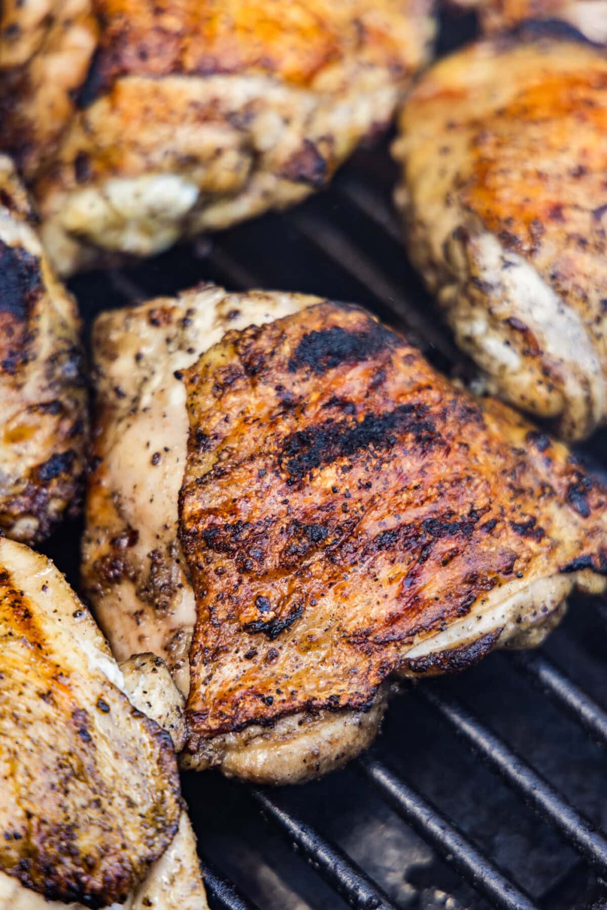 Grilled chicken thighs with golden char marks on a gas grill
