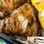 grilled chicken thigh on plate with some chicken taken out of it