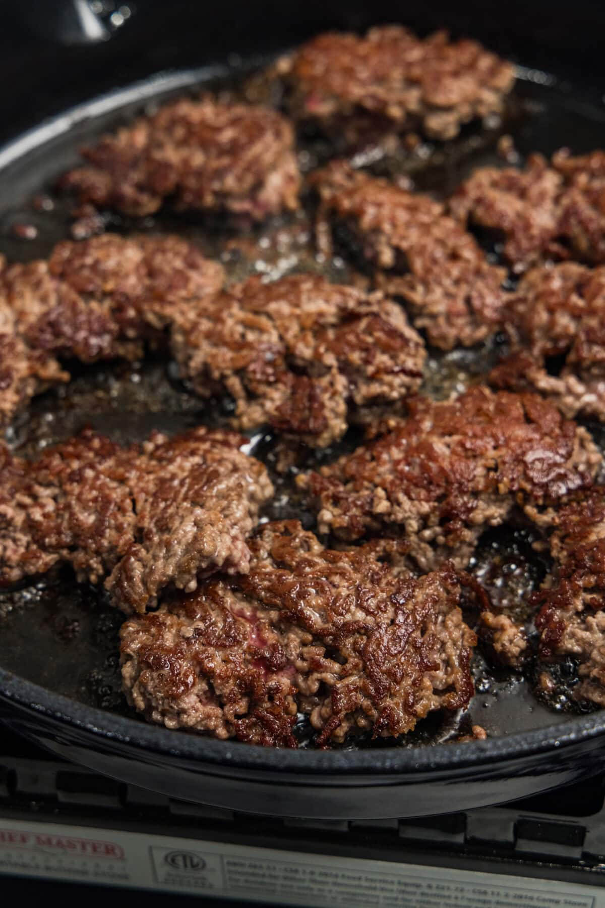 hunks of ground beef nicely browned and caramelized in skillet