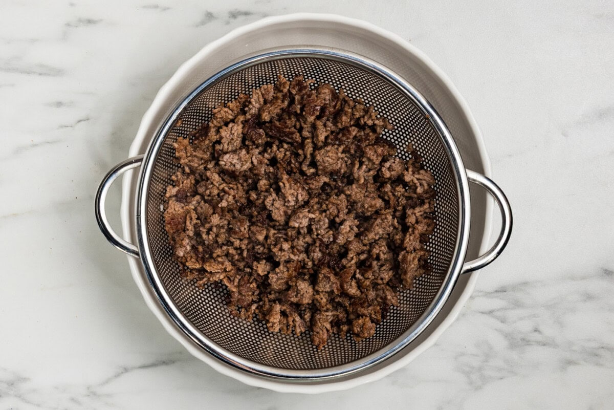browned ground beef in a colander