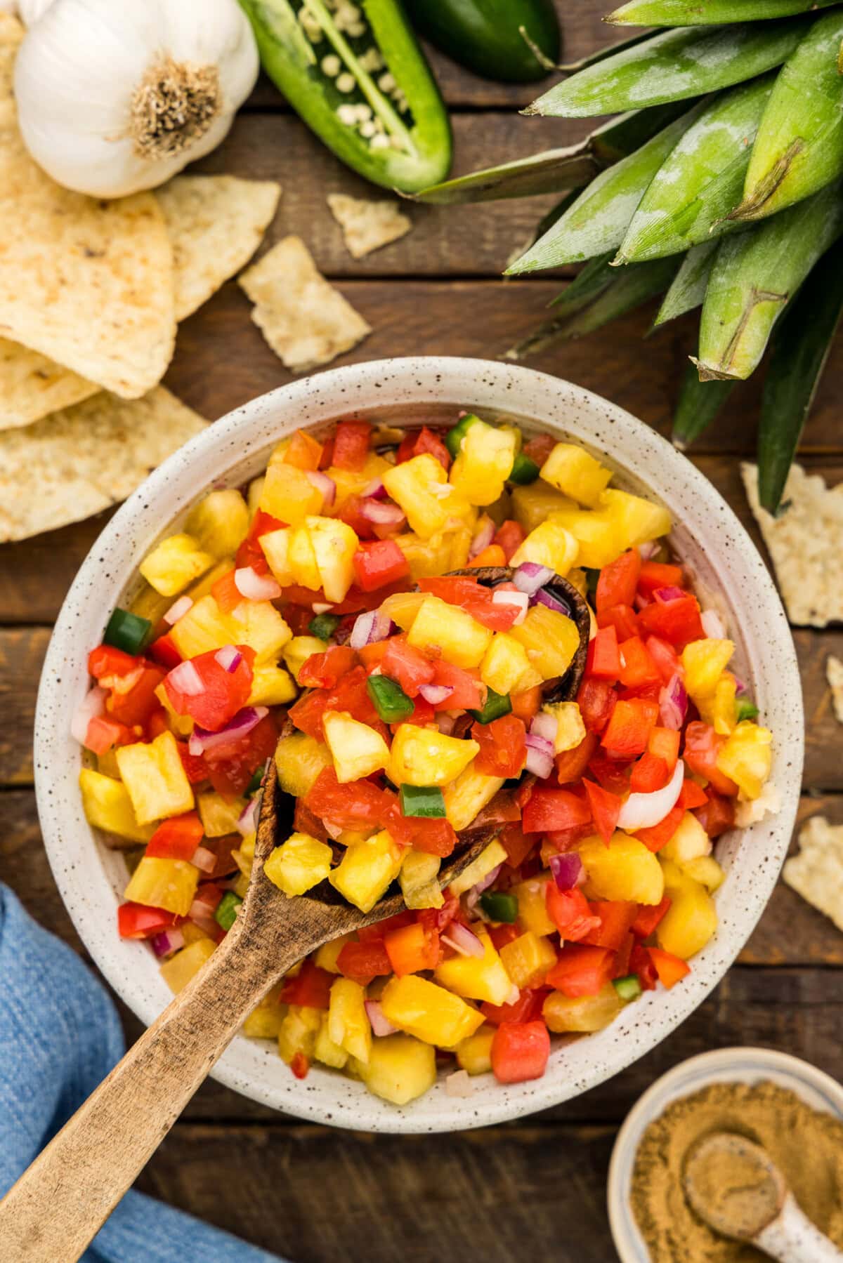 overhead photo of Pineapple Salsa with a wooden spoon