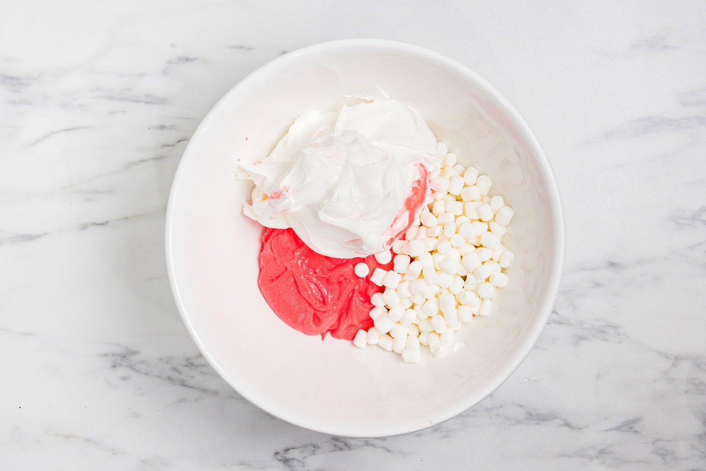 gelatin mixture, whipped cream, and marshmallows in a bowl