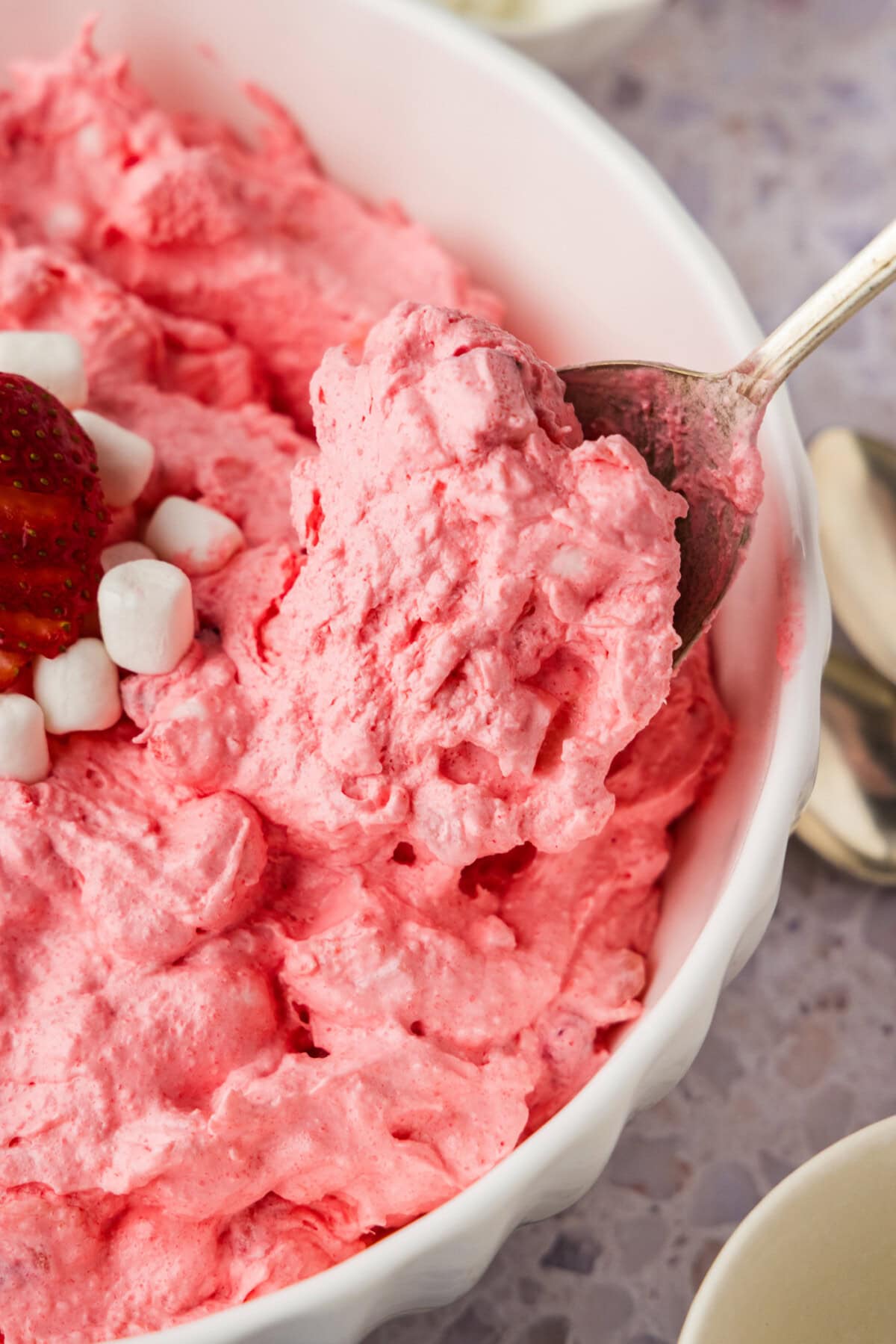 spoon lifting some Strawberry Fluff Salad from bowl