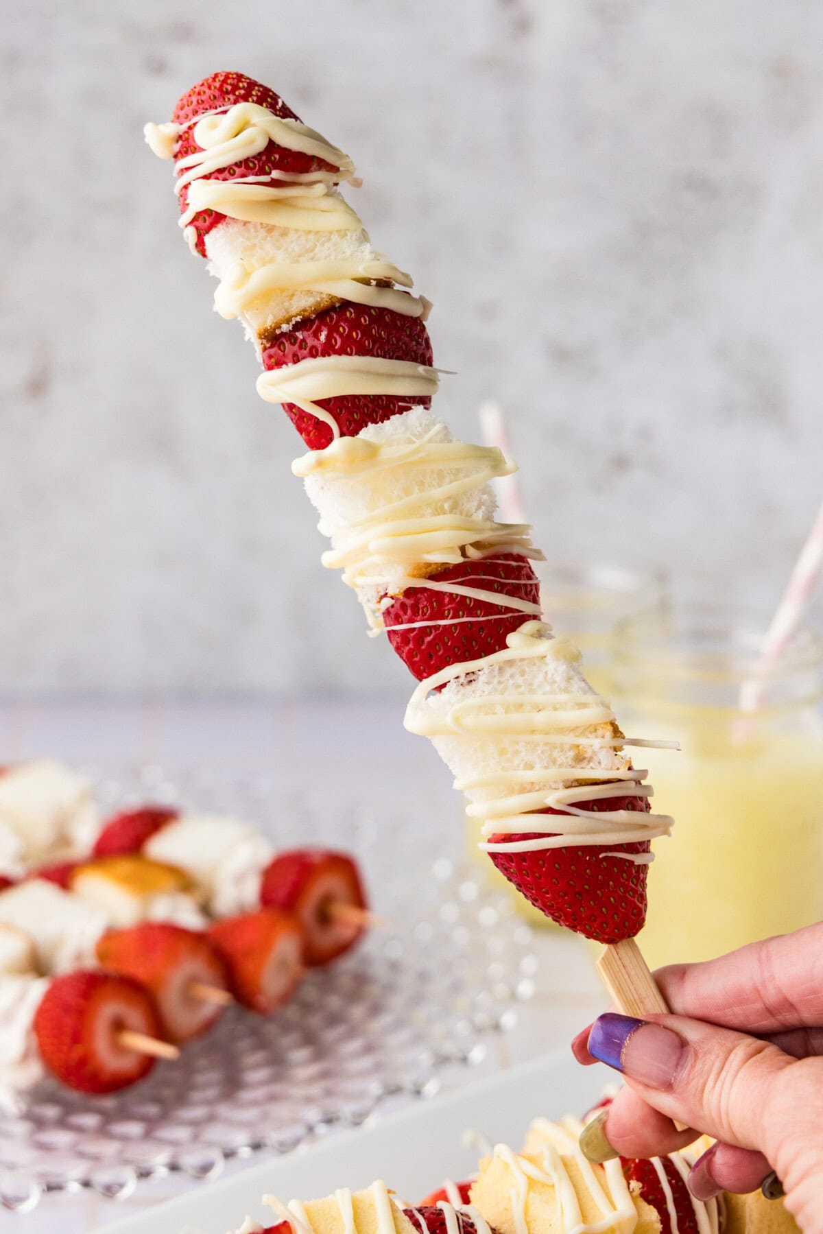 holding a Strawberry Shortcake Kabob with ore in the background