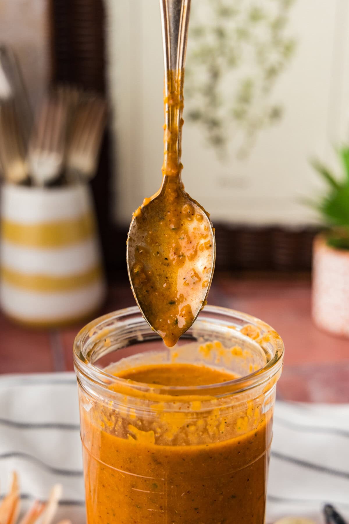 side view of spoon hovering over a jar of Baja Marinade