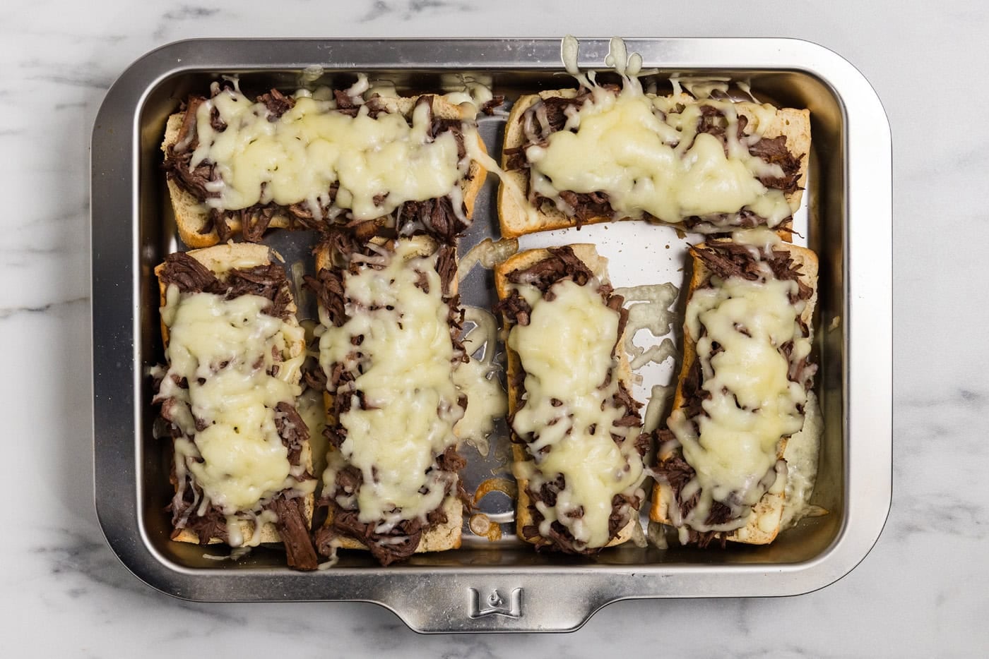 melted cheese on beef on rolls