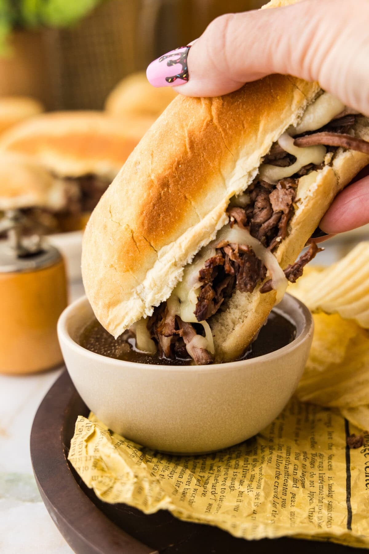 Crockpot French Dip Sandwich getting dipped in au jus