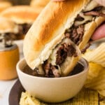 Crockpot French Dip Sandwich getting dipped in au jus