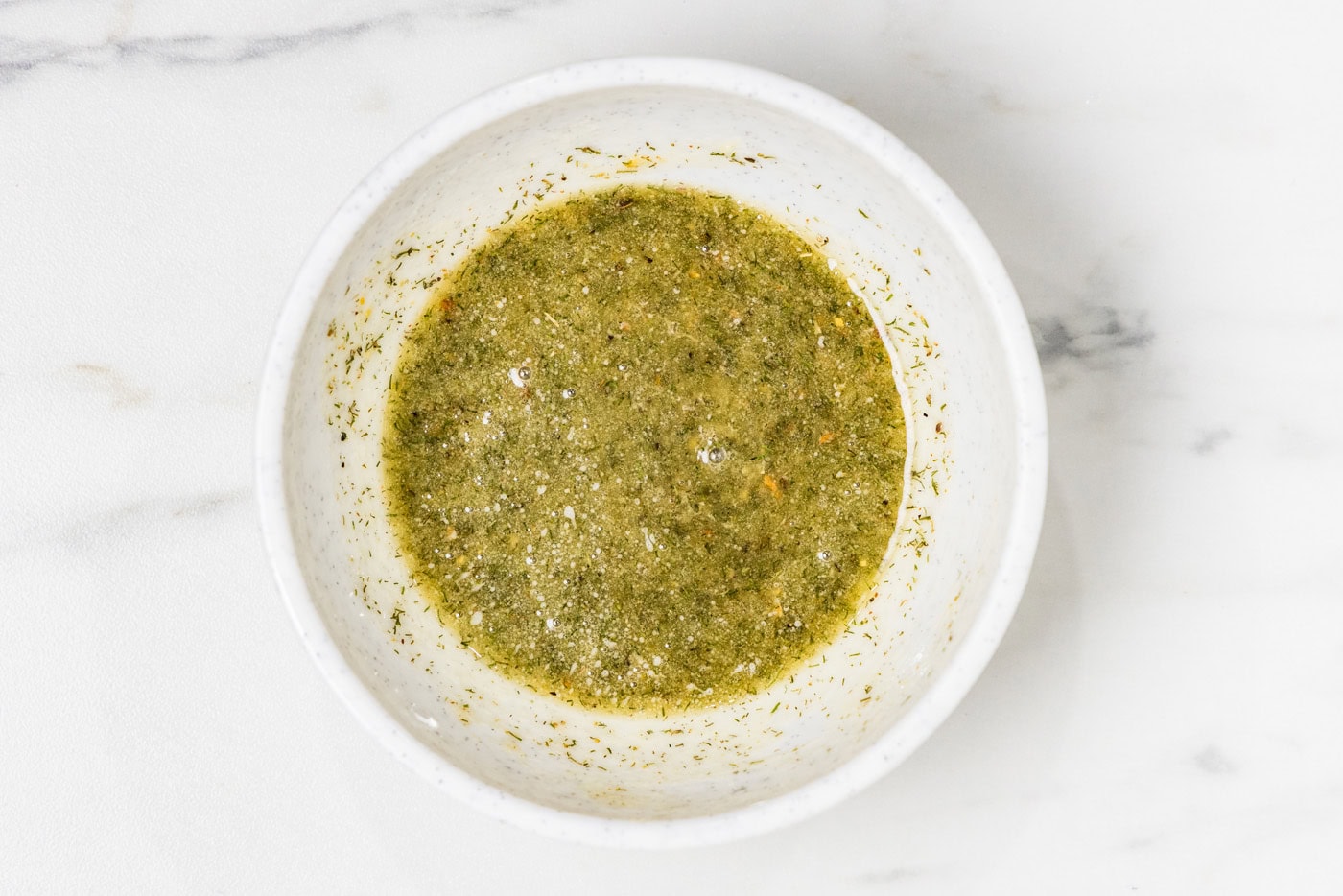 Butter, dill pickle seasoning, dill pickle juice, dried dill, and garlic powder mixed in a bowl