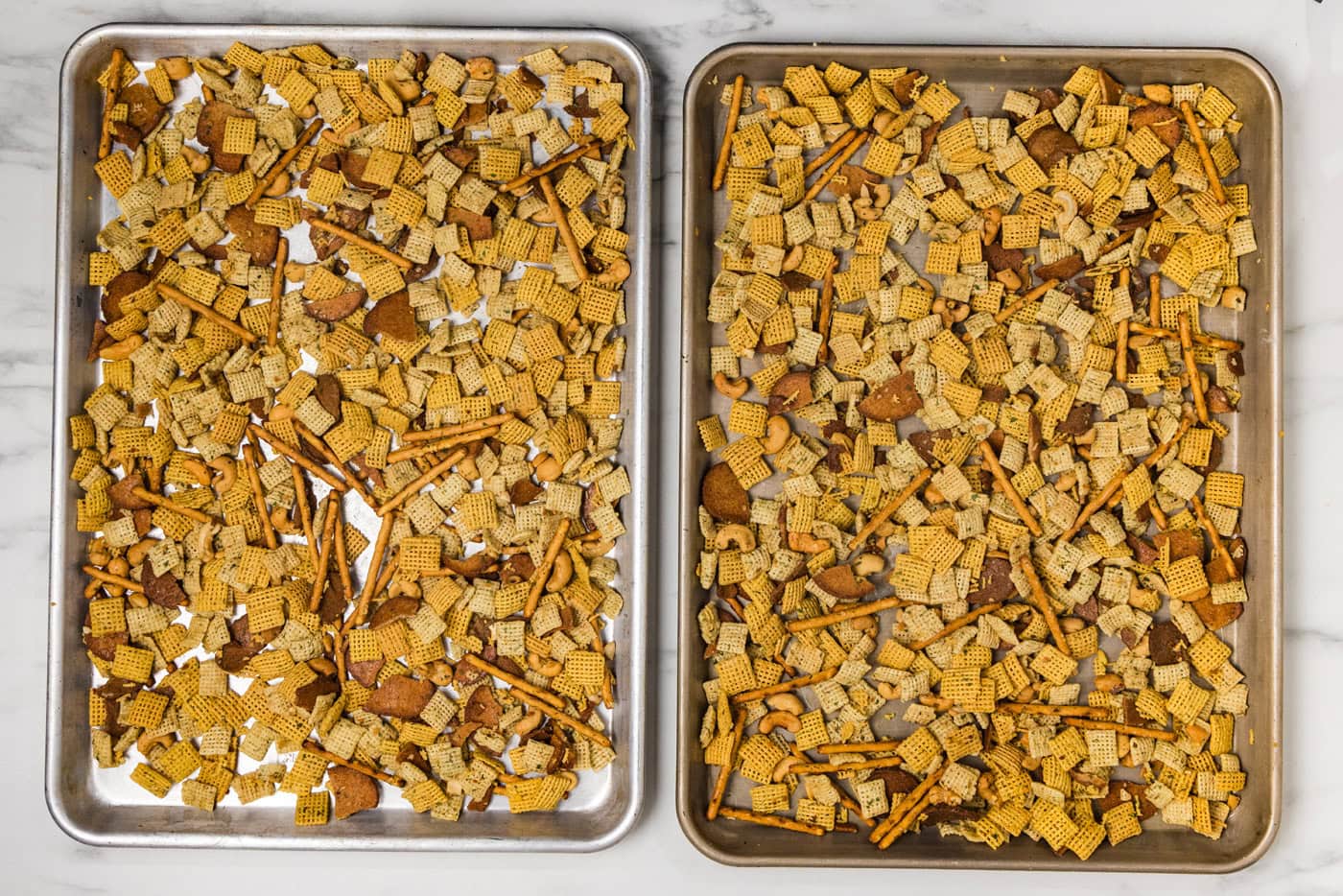 Dill pickle Chex mix ingredients spread out on jelly roll pans
