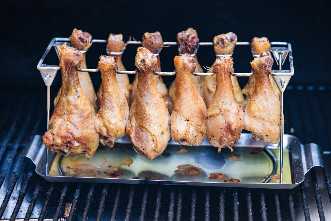 smoked chicken drumsticks on a chicken leg rack on smoker