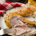 sliced open smoked chicken drumstick with fork