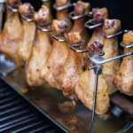 smoked chicken drumsticks on a chiken leg rack on the smoker