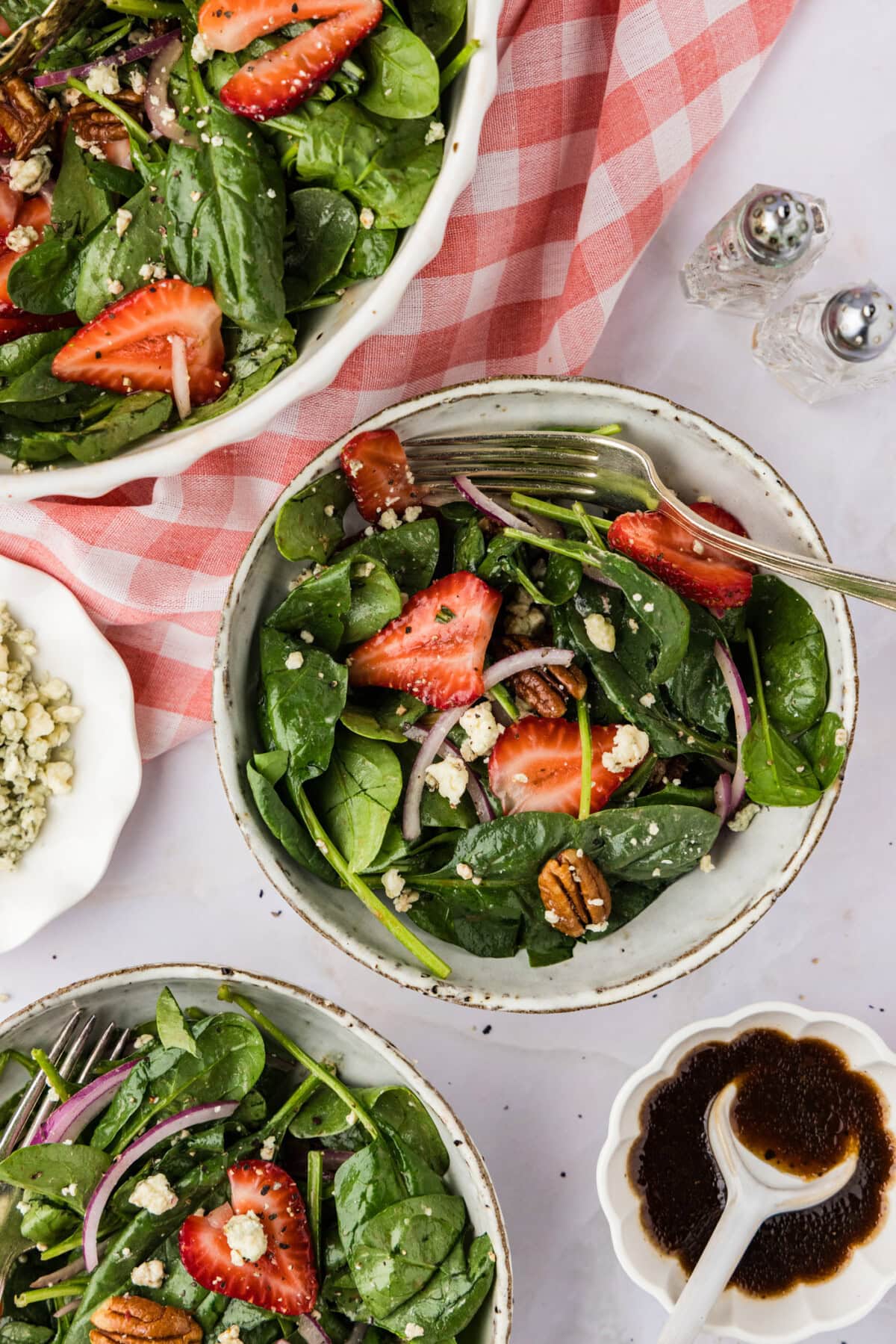 two bowls of Strawberry Spinach Salad with a pink checkered linen