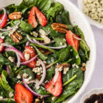 Strawberry Spinach Salad with dressing and crumbled cheese