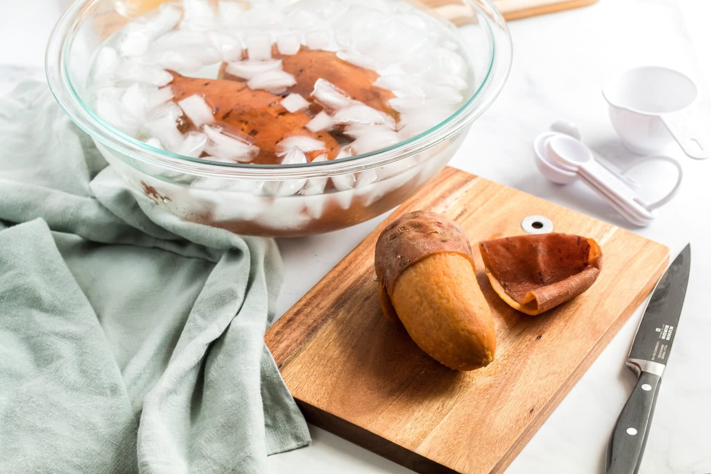 peeled sweet potato next to an ice bowl