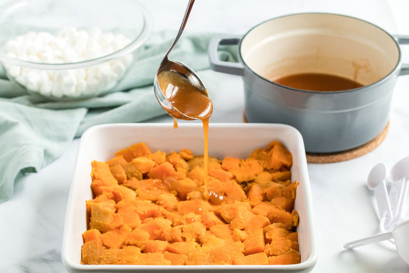 spooning sauce onto sweet potatoes