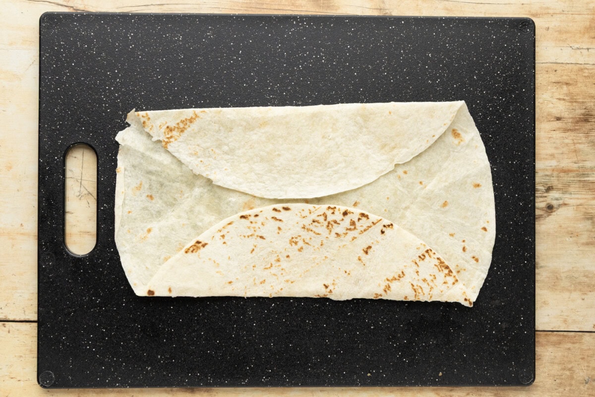 Flour tortilla with the top and bottom edges folded up over the center, leaving a rounded flap on each side