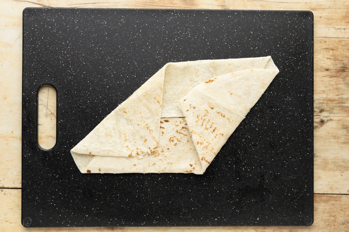Third fold laid alongside the previous one, the tortilla starting to take on straight angled edges