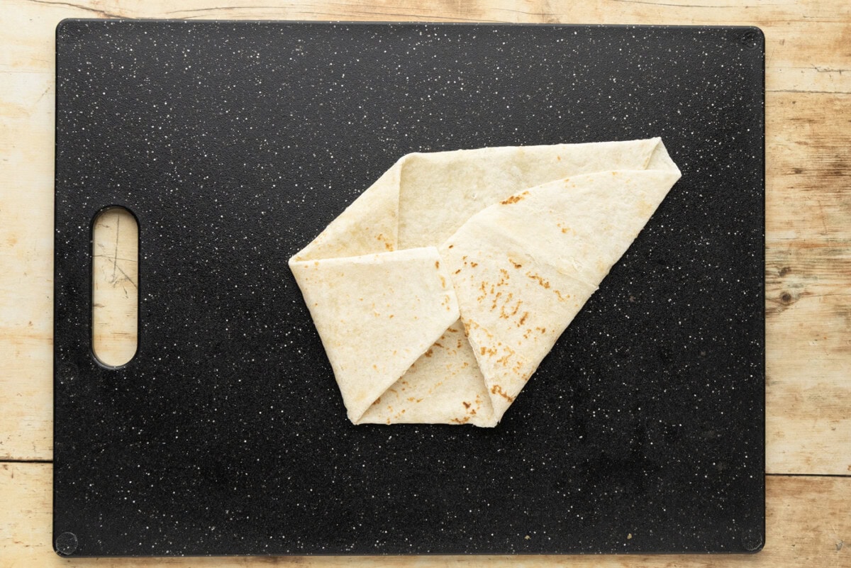 Tortilla folded down to a compact shape with four overlapping sections and one open flap remaining