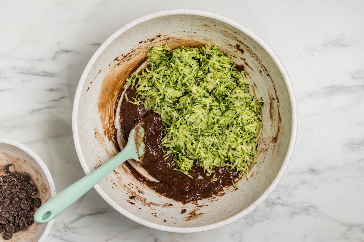 mixing shredded zucchini into batter