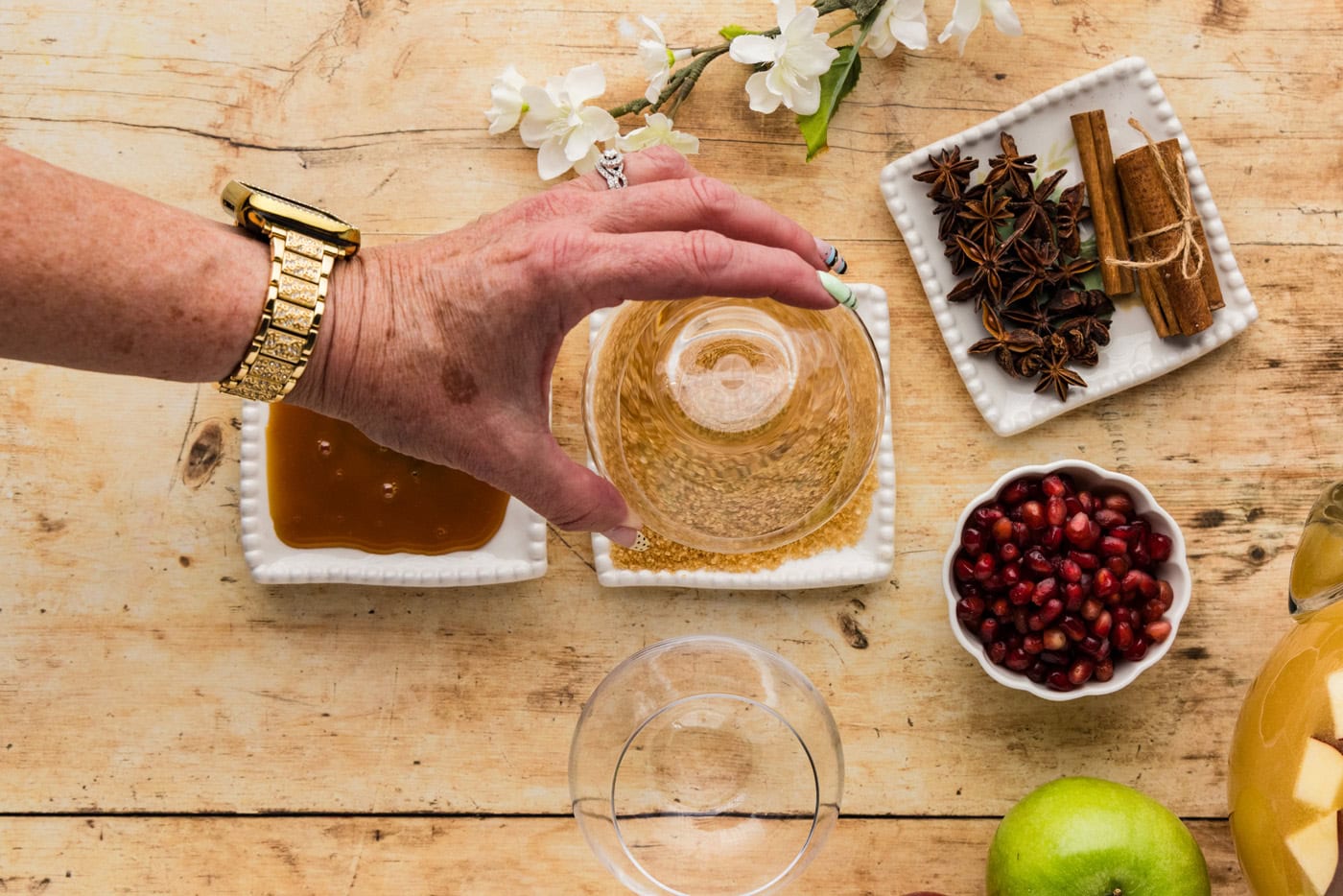 hand dipping rim of glass in turbinado sugar