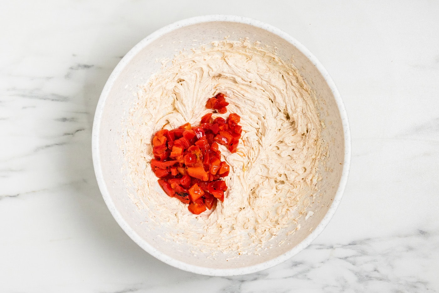 Chopped roasted red peppers added to the beaten cream cheese and taco seasoning mixture