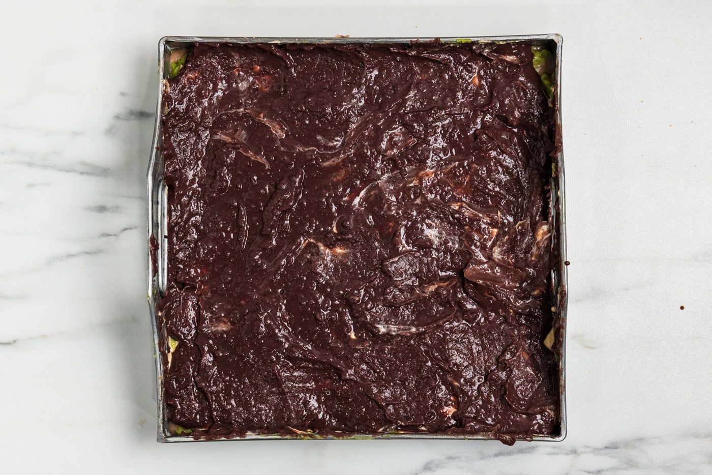 Black refried beans spread over the top of the layered dip to look like dark soil