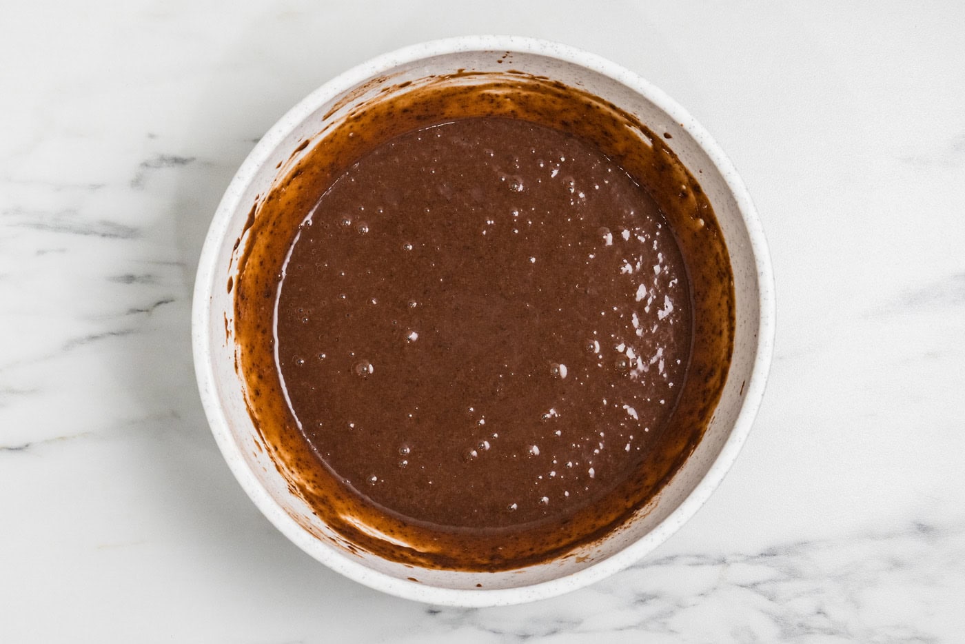 Instant chocolate pudding whisked with cold milk in a white mixing bowl