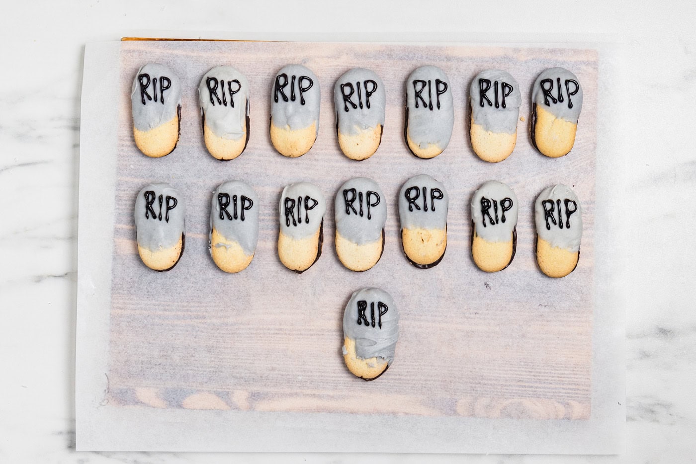 Milano cookies dipped in gray tinted white chocolate with RIP written on each one in black gel