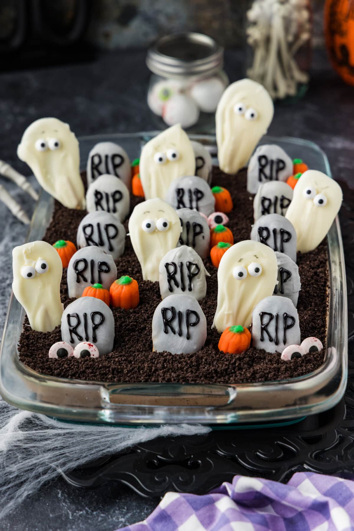 Halloween dirt cake in a glass 13x9 dish styled with cobwebs and Halloween decorations
