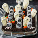 Halloween dirt cake in a glass 13x9 dish styled with cobwebs and Halloween decorations