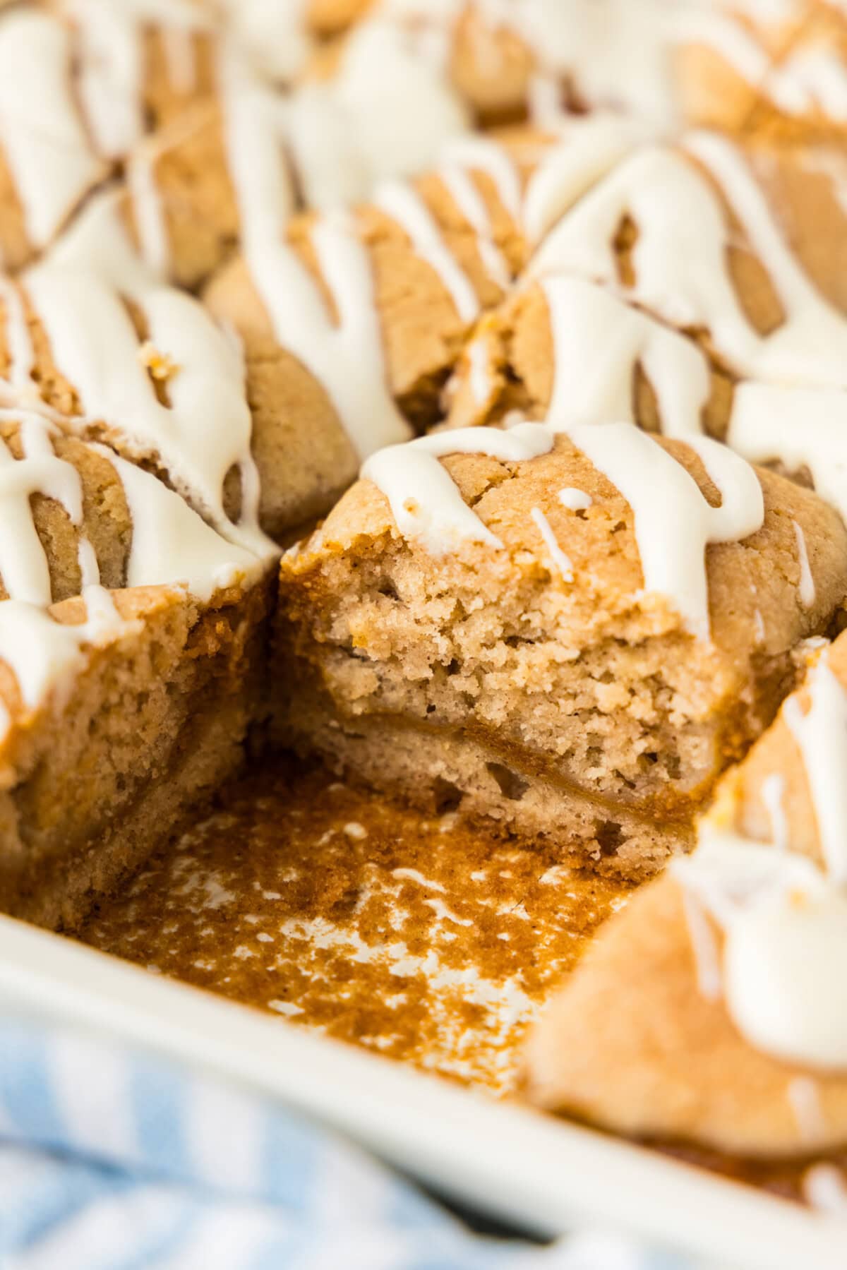 Close up of pumpkin pie squares in the pan with one square removed showing the pumpkin layer