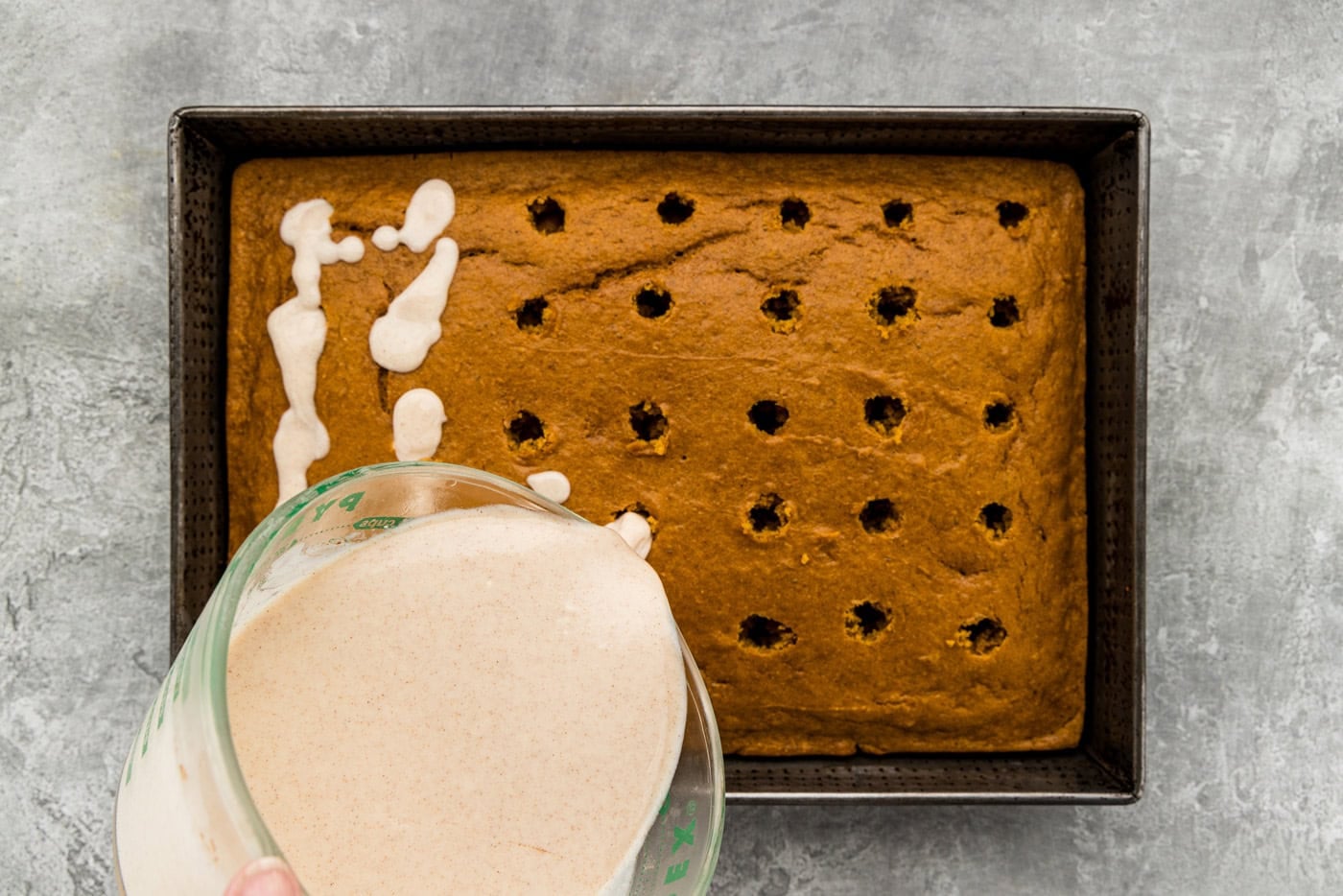 pouring thin pudding over holes in cake