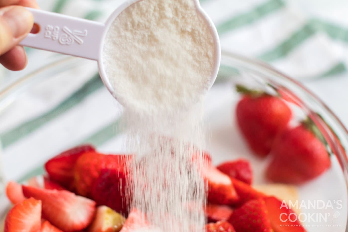 adding sugar to strawberries